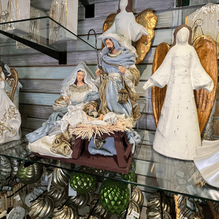 Nativity scene figurines with Mary, Joseph, and baby Jesus on a glass table  in the moments in thyme room at Dewayne's in Selma, NC