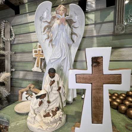 Decorative nativity scene with angel and cross on a wooden background in the moments in thyme room at Dewayne's in Selma, NC