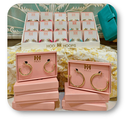 Pink jewelry display with 'Hoo Hoops' branding featuring gold hoop earrings in the boutique at Dewayne's in Selma, NC minutes from Raleigh, Cary, Clayton, Garner, Smithfield, Goldsboro