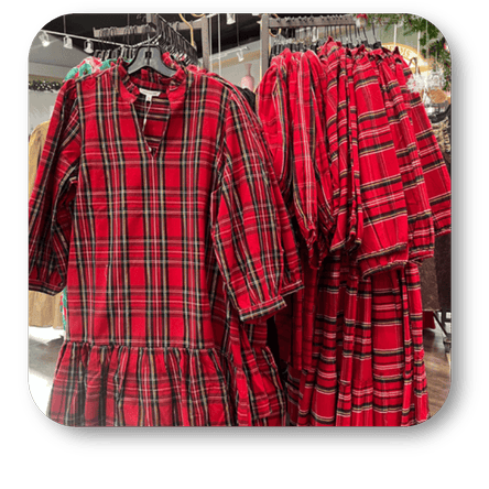 Red plaid dresses on a hanger with more dresses in the boutique at Dewayne's in Selma, NC minutes from Raleigh, Cary, Clayton, Garner, Smithfield, Goldsboro