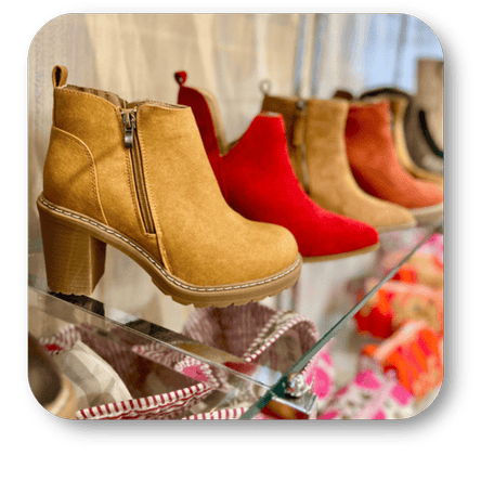 Row of colorful boots on a glass display case in the boutique at Dewayne's in Selma, NC minutes from Raleigh, Cary, Clayton, Garner, Smithfield, Goldsboro