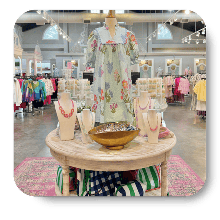 Mannequin wearing a floral dress in the boutique with various clothing items at Dewayne's in Selma, NC minutes from Raleigh, Cary, Clayton, Garner, Smithfield, Goldsboro
