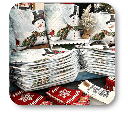 Stacks of Christmas-themed bags with snowmen and winter decorations at Dewayne's in Selma, NC minutes from Raleigh, Cary, Clayton, Garner, Smithfield, Goldsboro