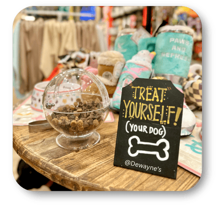 Glass bowl with treats on a wooden table with a sign reading 'Treat Yourself (Your Dog)' at Dewayne's in Selma, NC minutes from Raleigh, Cary, Clayton, Garner, Smithfield, Goldsboro