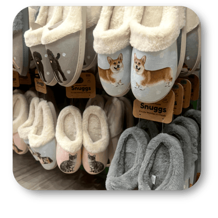 Display of slippers with dog illustrations and 'Snuggs' branding at Dewayne's in Selma, NC minutes from Raleigh, Cary, Clayton, Garner, Smithfield, Goldsboro