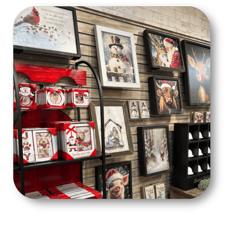Wall display of framed holiday pictures and decorative items at Dewayne's in Selma, NC minutes from Raleigh, Cary, Clayton, Garner, Smithfield, Goldsboro