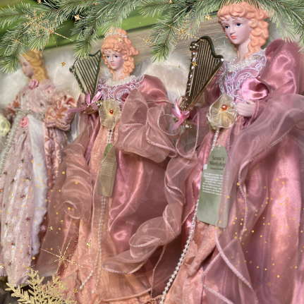 Decorative pink angel figurines with harps and flowers  in the gold and glamour room in christmas land 2025 at dewayne's