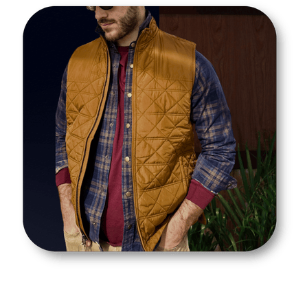 Man wearing a brown quilted vest over a plaid shirt with a dark background at Dewayne's in Selma, NC minutes from Raleigh, Cary, Clayton, Garner, Smithfield, Goldsboro