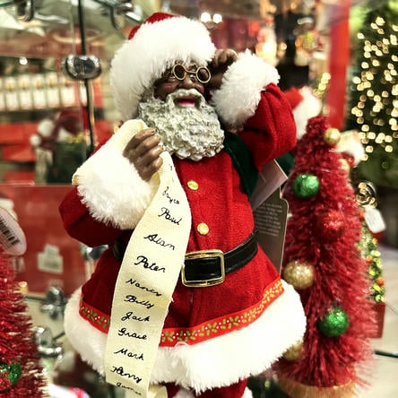 Decorative African American Santa Claus figure with a beard, standing in a store with Christmas decorations in the grand entrance room in christmas land 2025 at dewayne's