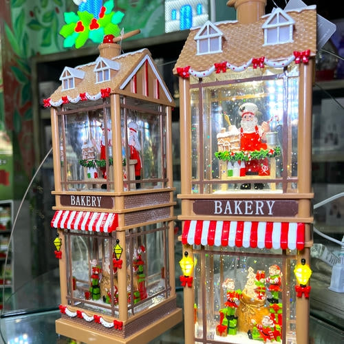 Lighted Christmas bakery models with Santa Claus figures inside located in the grand entrance room of Christmas land 2025 at Dewayne's