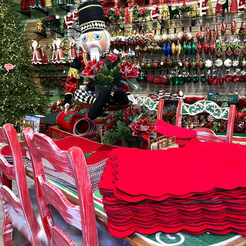 Christmas-themed table setting with red tablecloth, chairs, and decorations in the Grand entrance room of Christmas Land 2025 at Dewayne's