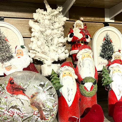 Decorative items including Santa figurines, a snow globe with birds, and Christmas trees in the country Christmas room of Christmas Land 2025 at Dewayne's