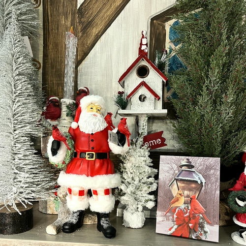 Decorative setup with Santa Claus figure, Christmas trees, and a birdhouse in the country Christmas room of Christmas Land 2025 at Dewayne's