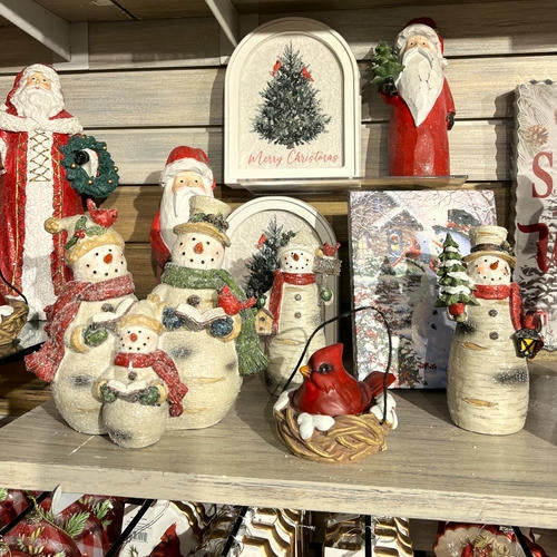Collection of Christmas-themed decorations including Santa Claus, snowmen, and a cardinal bird in the country Christmas room of Christmas Land 2025 at Dewayne's