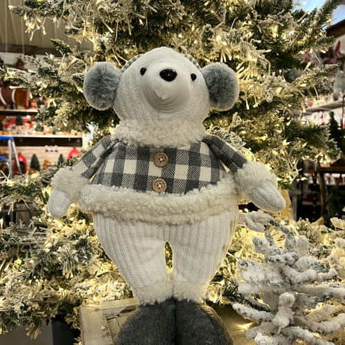 Plush polar bear toy wearing a checkered sweater in front of a Christmas tree in the country Christmas room of Christmas Land 2025 at Dewayne's