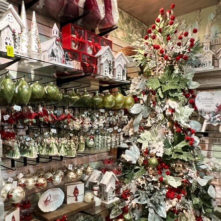 Display of Christmas ornaments including trees, houses, and other decorative items in the Moments in Thyme room at Dewayne's in Selma, NC