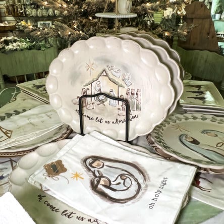 Decorative plates with Christmas nativity scenes on a table in the Moments in Thyme room at Dewayne's in Selma, NC