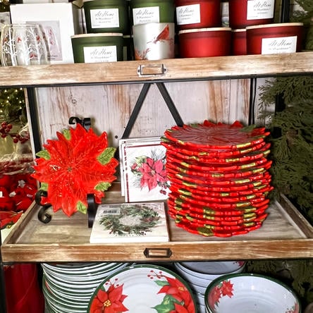 Stacks of red and green poinsettia ceramic plates and christmas candles  in the country christmas room at Dewayne's in Selma, NC