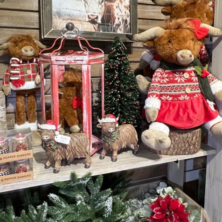 Decorative shelf with Christmas-themed decor and stuffed highland cows in the country christmas room at Dewayne's in Selma, NC