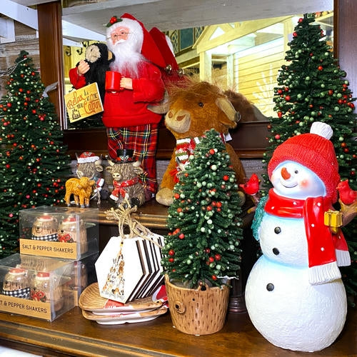 Decorative Christmas scene with Santa Claus, highland cow plush and snowman on a shelf in the country Christmas room of Christmas Land 2025 at Dewayne's