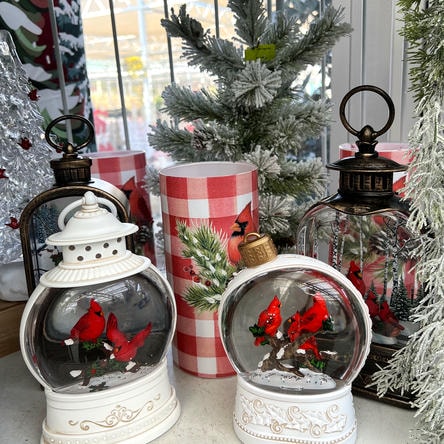 Two snow globes with cardinals on a table with Christmas decor at Dewayne's in Selma, NC minutes from Raleigh, Cary, Clayton, Garner, Smithfield, Goldsboro