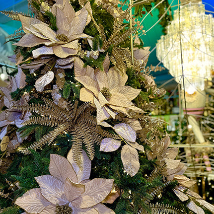 golden decorated christmas tree with gold poinsettias in the gold and glamour room in christmas land 2025 at dewayne's