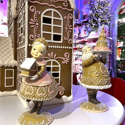 Decorative mr and mrs clause figurines in front of a gingerbread house display in Kringle's kitchen in christmas land 2025 at dewayne's