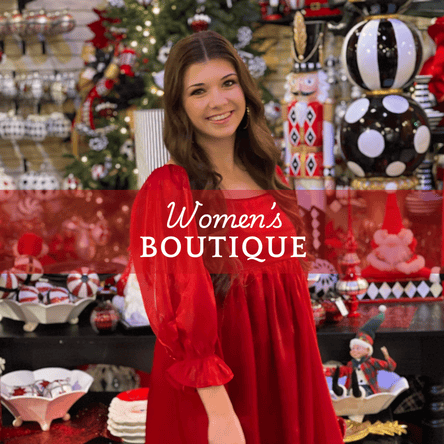 Woman in a red dress standing in front of a Christmas-themed store display  in the Women's Boutique at Dewayne's in Selma, NC minutes from Raleigh, Cary, Clayton, Garner, Smithfield, Goldsboro