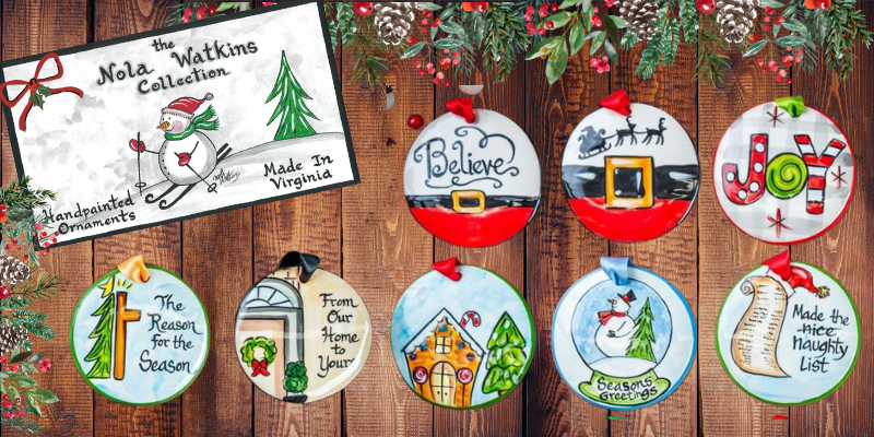 Decorative Christmas ornaments with holiday-themed designs on a wooden background, featuring the Nola Watkins Collection branding.