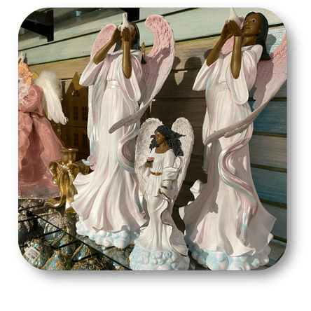 Set of african american angel figurines with different poses and expressions in the background in the gold and glamour room in christmas land at Dewayne's in Selma, NC minutes from Raleigh, Cary, Clayton, Garner, Smithfield, Goldsboro