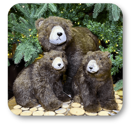 Three decorative brown rustic bears sitting together in front of a Christmas tree in the country Christmas room of Christmas Land at Dewayne's in Selma, NC minutes from Raleigh, Cary, Clayton, Garner, Smithfield, Goldsboro