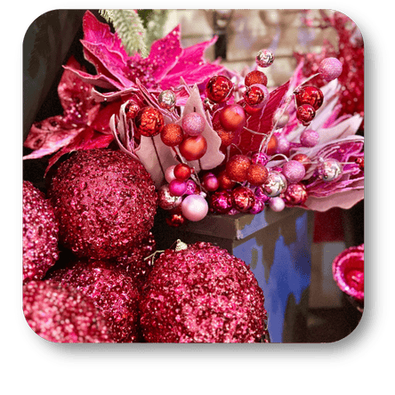 Close-up of pink glittery ornaments and poinsettias with a blurred background  in the wrapped in red room in christmas land at Dewayne's in Selma, NC minutes from Raleigh, Cary, Clayton, Garner, Smithfield, Goldsboro