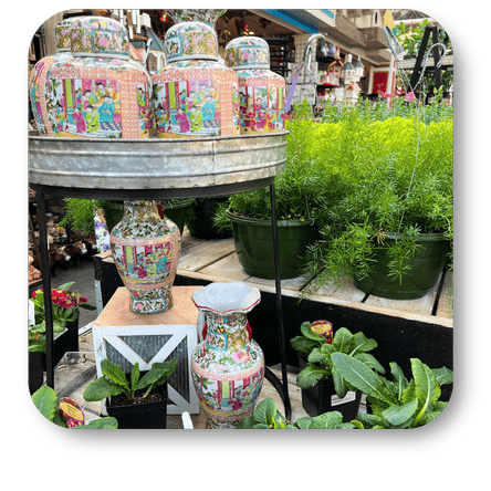 Decorative ceramic vases with colorful patterns on a table with a variety of indoor plants in the greenhouse atrium at Dewayne's in Selma, NC minutes from Raleigh, Cary, Clayton, Garner, Smithfield, Goldsboro