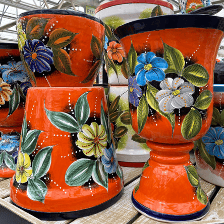 Set of Talavera orange ceramic pots with floral designs in the garden center at dewayne's