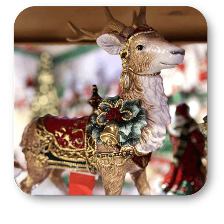 Decorative Fitz and floyd reindeer figurine with gold antlers and a red saddle in the grand entrance room of christmas land at Dewayne's in Selma, NC minutes from Raleigh, Cary, Clayton, Garner, Smithfield, Goldsboro
