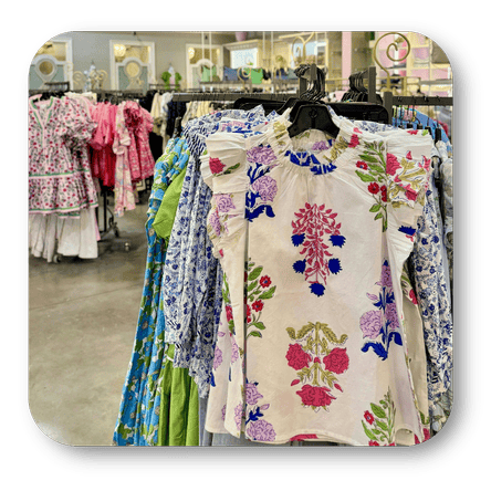 Colorful floral blouse and dresses on hangers in the boutique at Dewayne's in Selma, NC minutes from Raleigh, Cary, Clayton, Garner, Smithfield, Goldsboro