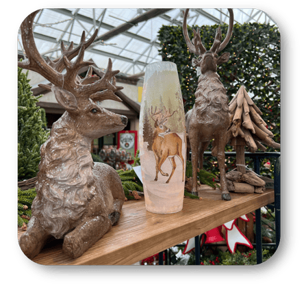 Decorative deer statues and glass globe with deer illustration on a shelf at Dewayne's in Selma, NC minutes from Raleigh, Cary, Clayton, Garner, Smithfield, Goldsboro