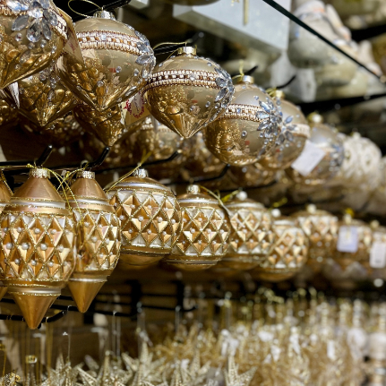 Gold Christmas ornaments with intricate designs  in the gold and glamour room in christmas land 2025 at dewayne's