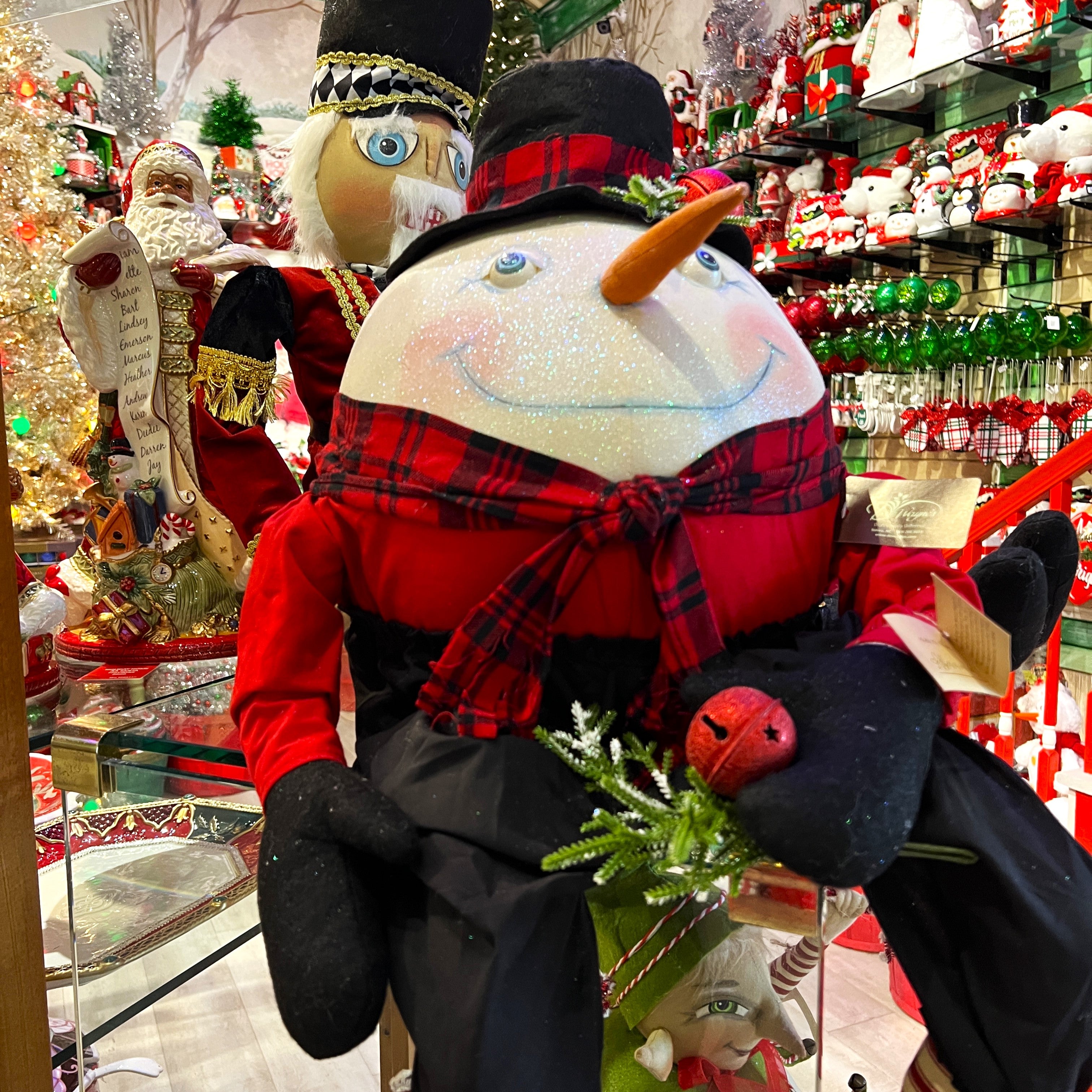Large Decorative snowman figure with plaid scarf and red hat in the grand entrance room of christmas land 2025 at Dewayne's