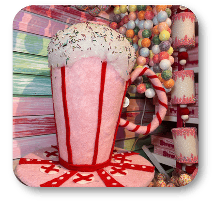 Decorative hot chocolate mug with candy cane and marshmallows against a colorful background in the Kringle's Kitchen room in christmas land 2025 at Dewayne's in Selma, NC minutes from Raleigh, Cary, Clayton, Garner, Smithfield, Goldsboro