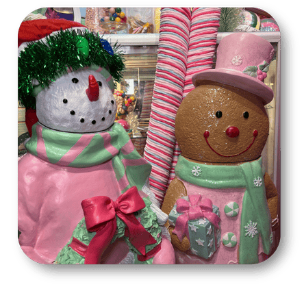 Decorative snowman and gingerbread man figures with pink scarves and hats in a festive setting in the Kringle's Kitchen room in christmas land at Dewayne's in Selma, NC minutes from Raleigh, Cary, Clayton, Garner, Smithfield, Goldsboro