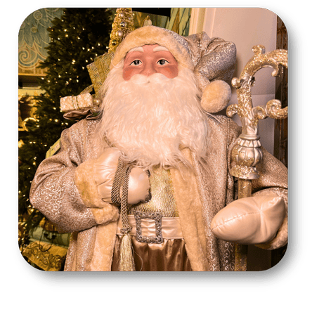 Decorative gold santa in a festive setting with a Christmas tree  in the gold and glamour room in christmas land at Dewayne's in Selma, NC minutes from Raleigh, Cary, Clayton, Garner, Smithfield, Goldsboro