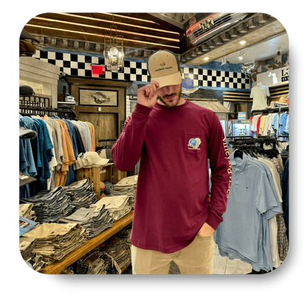 Man wearing a maroon shirt with a logo in the men's shoppe at Dewayne's in Selma, NC minutes from Raleigh, Cary, Clayton, Garner, Smithfield, Goldsboro