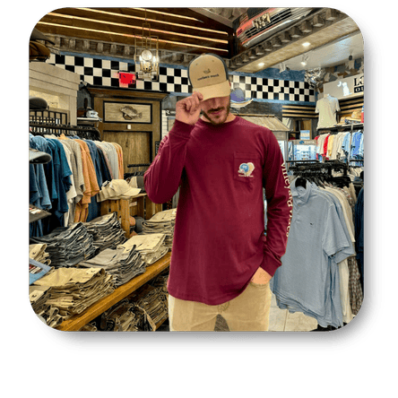 Man wearing a maroon shirt with a logo in the men's shoppe at Dewayne's in Selma, NC minutes from Raleigh, Cary, Clayton, Garner, Smithfield, Goldsboro