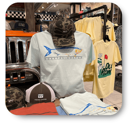 Collection of coastal cotton t-shirts and caps on display with a vintage car in the men's shoppe at Dewayne's in Selma, NC minutes from Raleigh, Cary, Clayton, Garner, Smithfield, Goldsboro