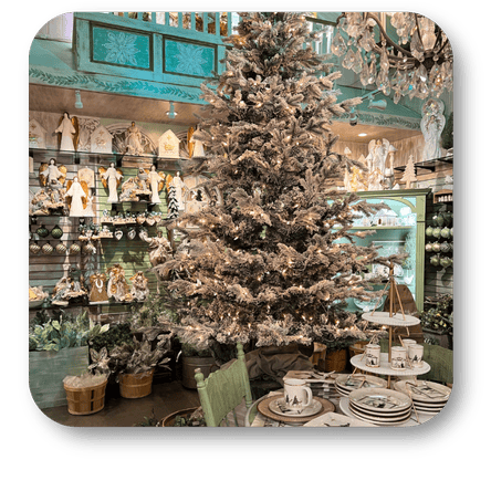 Decorative Christmas tree in a store with various ornaments and a chandelier in the moments of thyme room in christmas land 2025 at Dewayne's in Selma, NC minutes from Raleigh, Cary, Clayton, Garner, Smithfield, Goldsboro