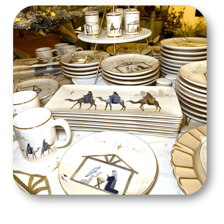 Collection of ceramic plates and mugs with decorative designs of the three wisemen on a table in the moments of thyme room in christmas land 2025 at Dewayne's in Selma, NC minutes from Raleigh, Cary, Clayton, Garner, Smithfield, Goldsboro