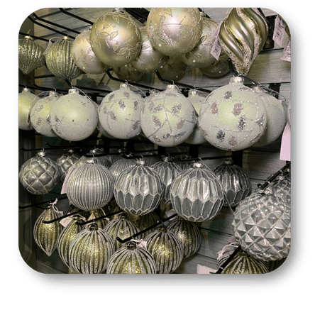 Collection of silver and gold Christmas ornaments on a stand in the moments of thyme room in christmas land 2025 at Dewayne's in Selma, NC minutes from Raleigh, Cary, Clayton, Garner, Smithfield, Goldsboro
