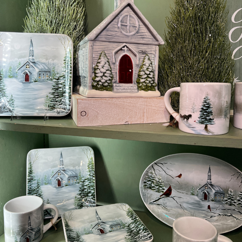 Decorative snowy christmas items including plates, mugs, and holiday ceramic houses  in the moments of thyme room in christmas land 2025 at dewayne's