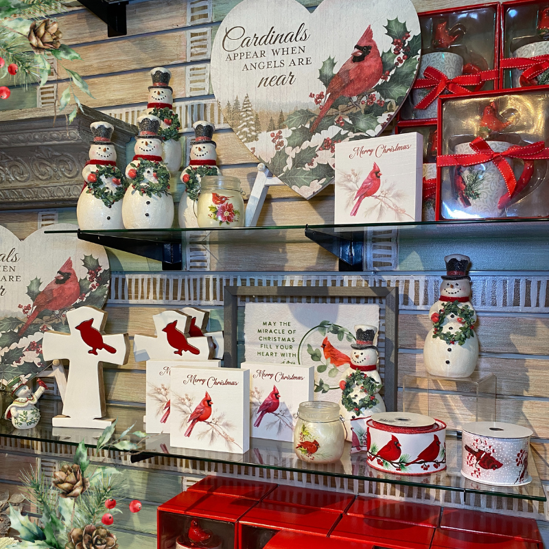 Collection of Christmas-themed decor items including cardinals, snowmen, and festive cards  in the moments of thyme room in christmas land 2025 at dewayne's